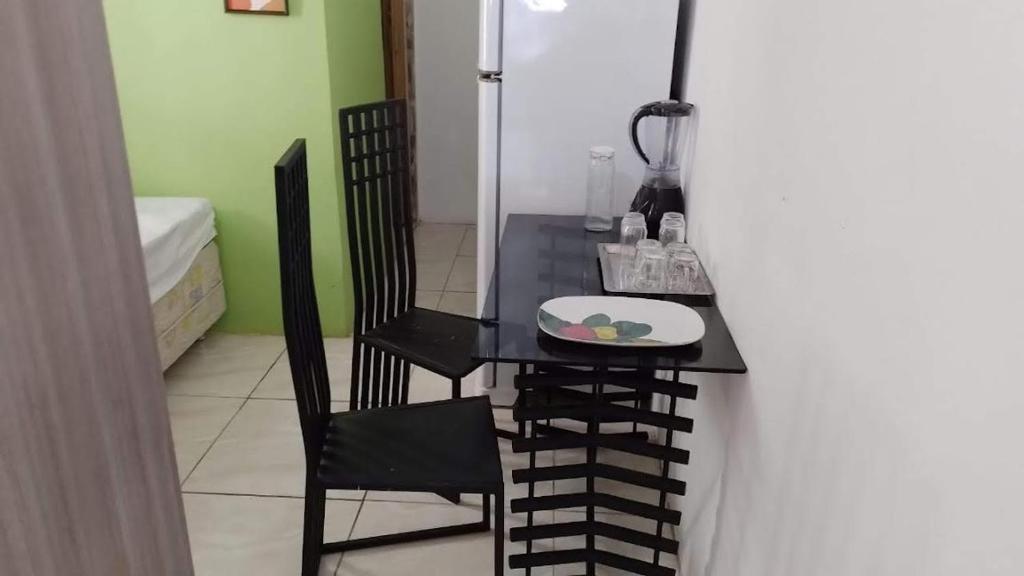 uma mesa e uma cadeira com um prato de comida em Espaço interno em Salvador