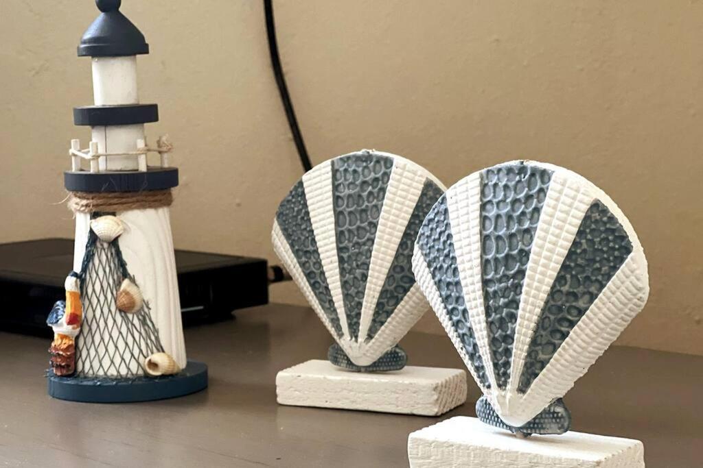 dos esculturas de un barco y un faro sobre una mesa en Orsini Beach Apartment, en Aguadilla