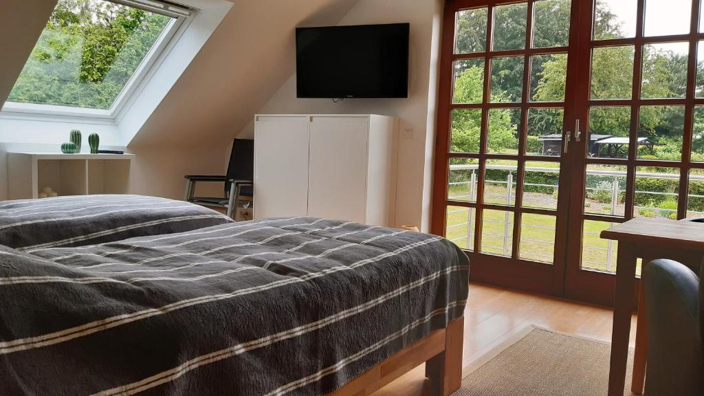 1 dormitorio con 1 cama y TV en la pared en Haus Drebes, en Wetter