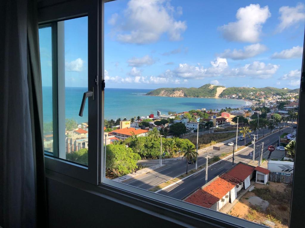 ventana con vistas a la ciudad y al océano en Flat Ponta Negra, en Natal