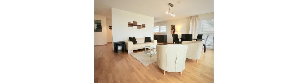 a living room with a white table and chairs at Bright spacious and modern apartment with terrace in Lausanne