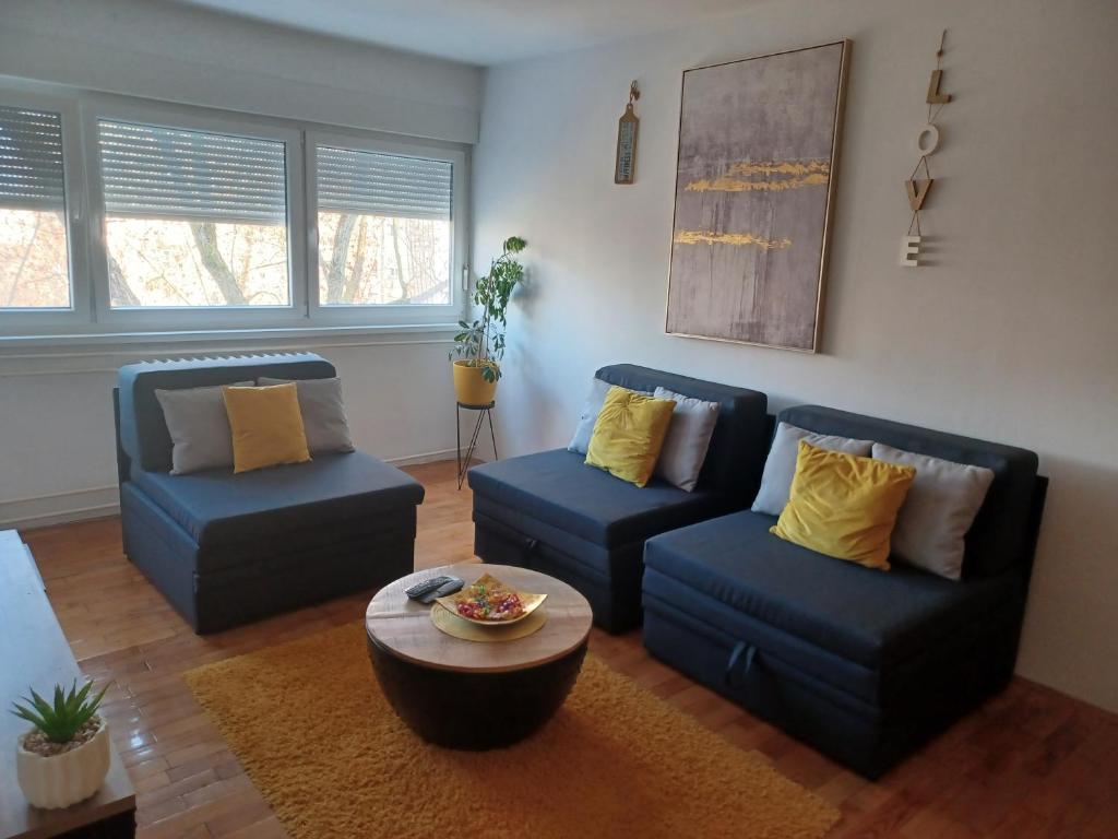a living room with two blue chairs and a table at Apartment M&amp;A in Osijek