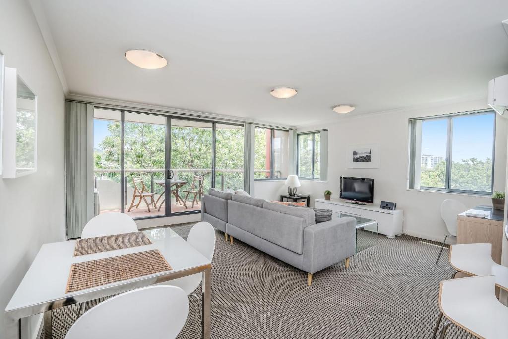 a living room with a couch and a tv at CityStyle Apartments in Canberra