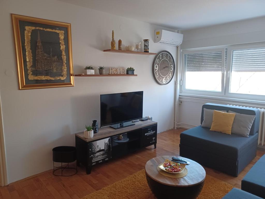 a living room with a couch and a flat screen tv at Apartment M&amp;A in Osijek