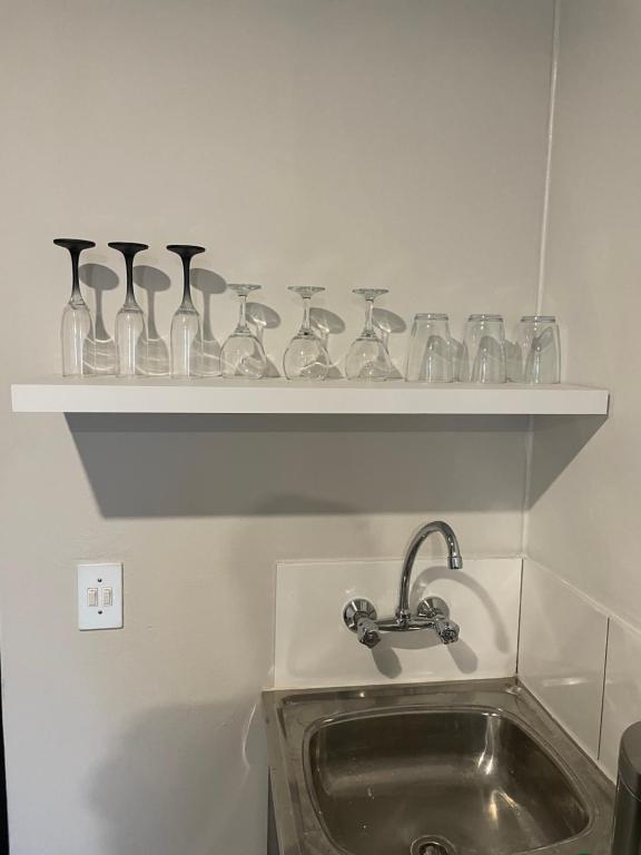 a shelf with glass vases on it next to a sink at Little Heaven in Johannesburg