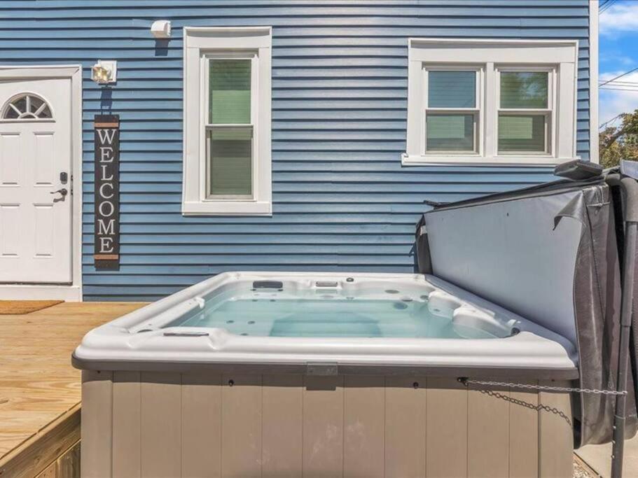 a hot tub in front of a blue house at Pets, Big Groups Welcome: HotTub, Firepit, Grill in Bay City