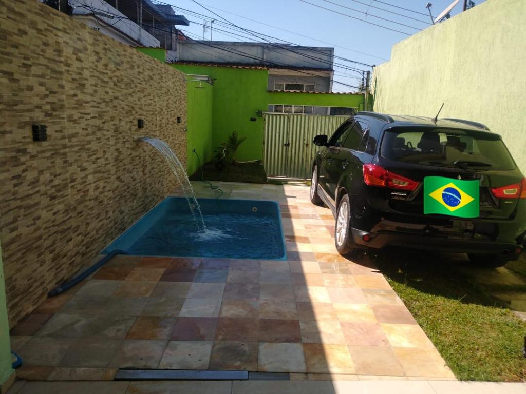 ein Auto, das in einer Einfahrt mit einem Brunnen parkt in der Unterkunft CASA GRIEBELER in Rio de Janeiro