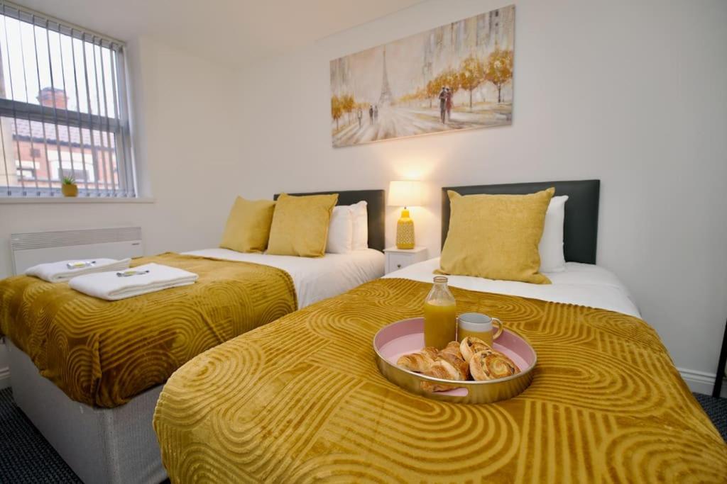 a hotel room with two beds with a bowl of food on the bed at Swan Studio Two - Coventry in Coventry