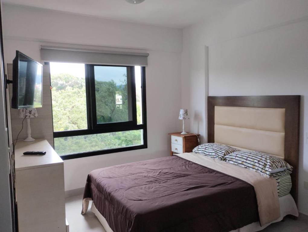 1 dormitorio con cama y ventana en Departamento XIBI en San Salvador de Jujuy