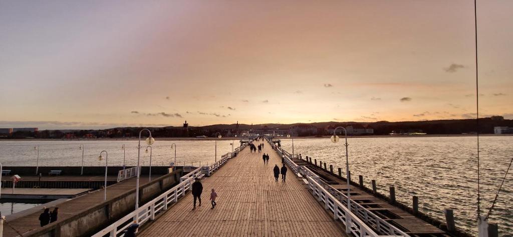 a group of people walking on a pier over the water at Sopot Baltic in Sopot