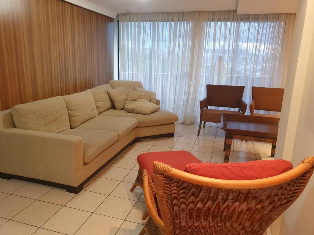 uma sala de estar com um sofá e algumas cadeiras em Apartamento Caruaru em Caruaru