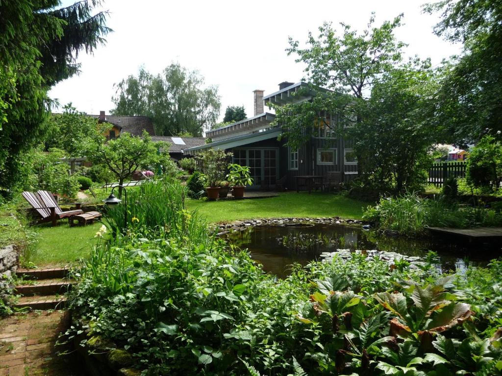 einen Garten mit einem Teich vor einem Haus in der Unterkunft Ferienhaus Gartenlust in Dierdorf