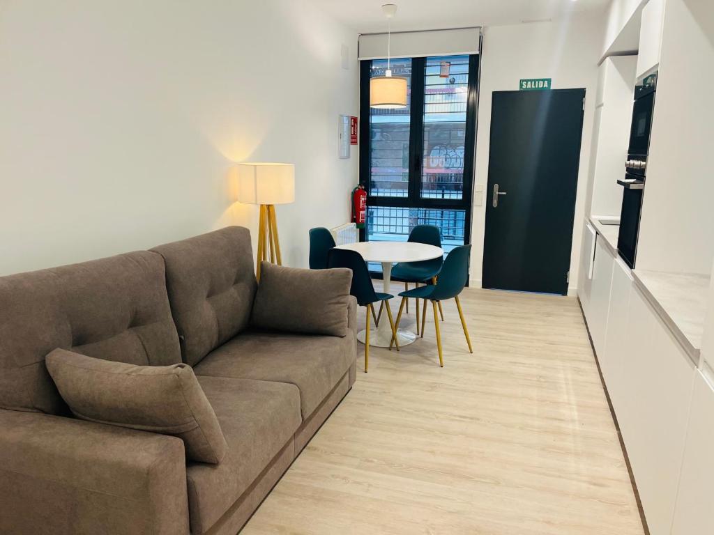 ein Wohnzimmer mit einem Sofa, einem Tisch und Stühlen in der Unterkunft PISOS NUEVOS MONCLOA ARGUELLES in Madrid