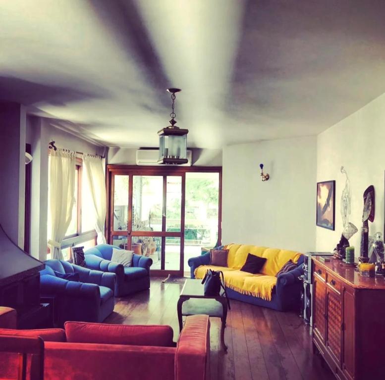 a living room with a yellow couch and blue couches at Apto Bonfim Redenção 2 carros e sacada vip in Porto Alegre