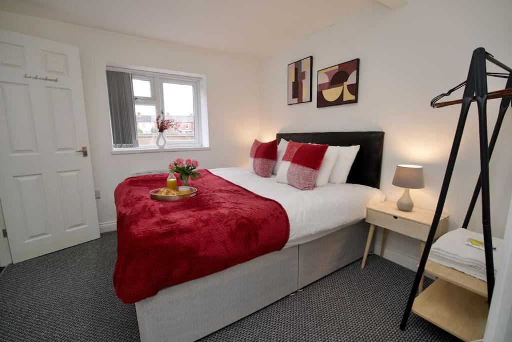 um quarto com uma cama com um cobertor vermelho em Swan Studio Five - Coventry em Coventry