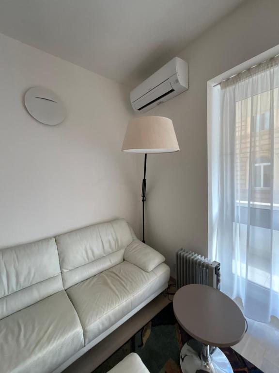uma sala de estar com um sofá branco e uma mesa em Monolocale em Roma