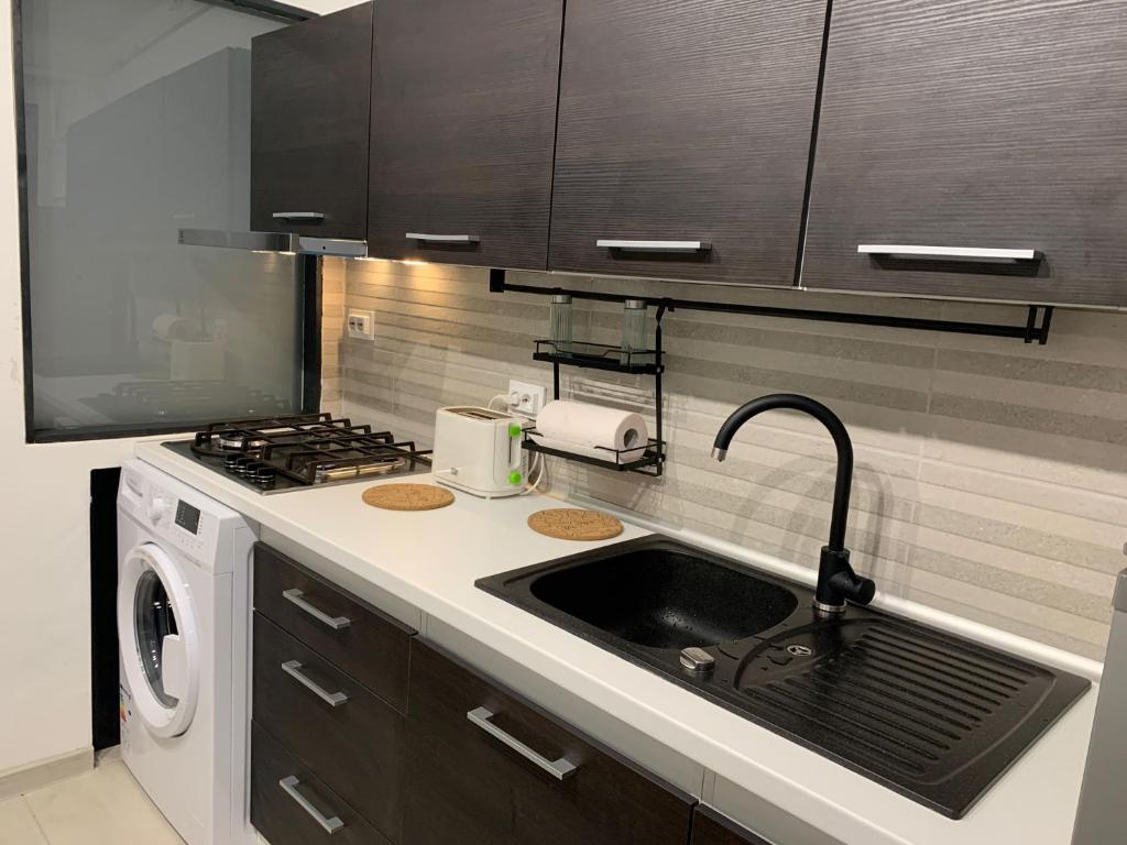 a kitchen with a sink and a stove at Central Apartament in Bîrlad