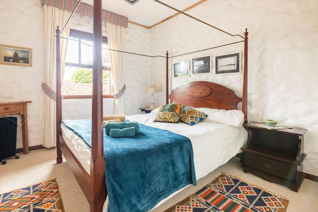 1 dormitorio con cama con dosel y manta azul en La Vie en Rose, en Campos do Jordão
