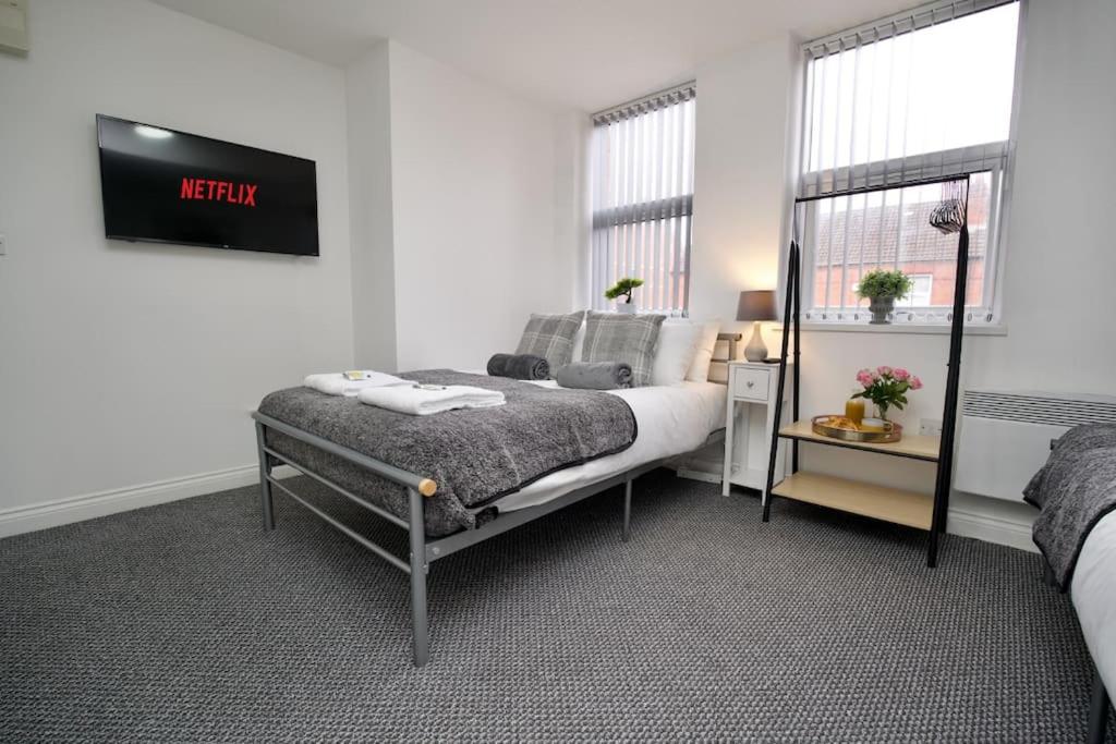 um quarto com uma cama e uma placa na parede em Swan Studio Seven - Coventry em Coventry