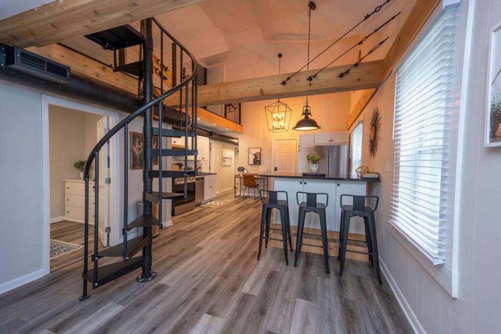 uma cozinha e sala de estar com uma escada num loft em Large-group Retreat w/Loft Space Near Beach em Michigan City
