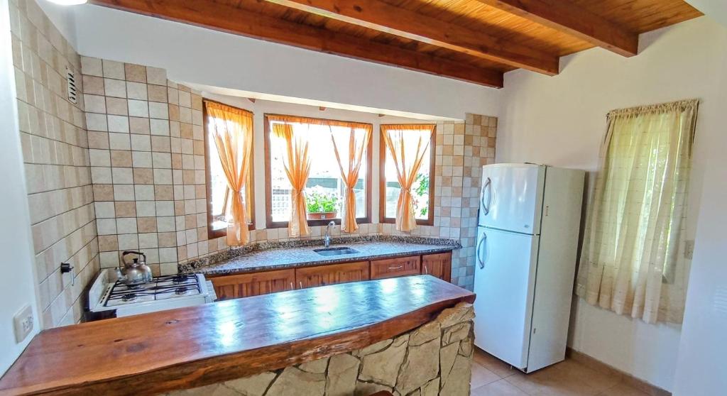 eine Küche mit einem weißen Kühlschrank und einem Fenster in der Unterkunft Alma de Maitén in San Carlos de Bariloche