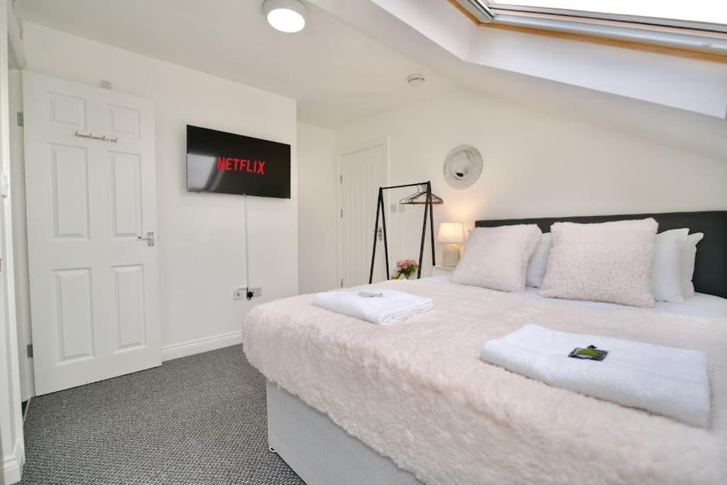 ein weißes Schlafzimmer mit einem großen Bett und einem Schild an der Wand in der Unterkunft Swan Studio Nine - Coventry in Coventry