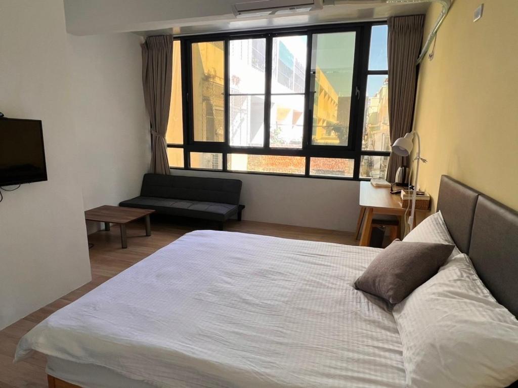 ein Schlafzimmer mit einem Bett und einem großen Fenster in der Unterkunft Chia Lung Gold Coast Homestay in Hu-nei