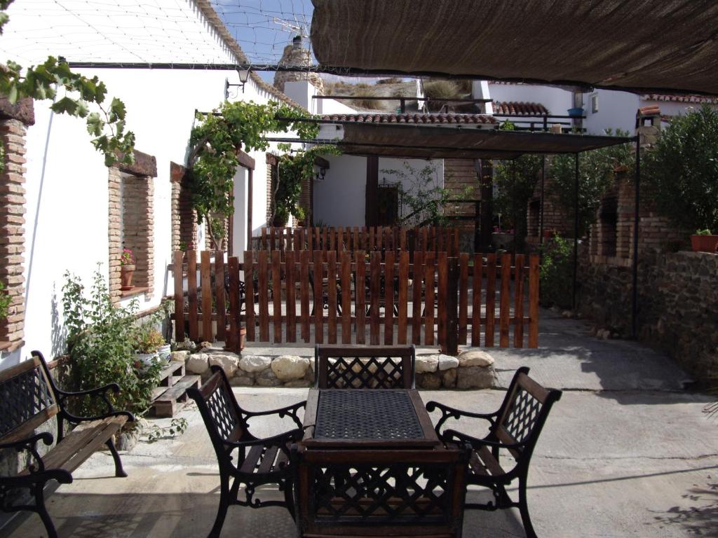 un patio con tavolo, sedie e una recinzione di Cuevas Rio Baza a Baza