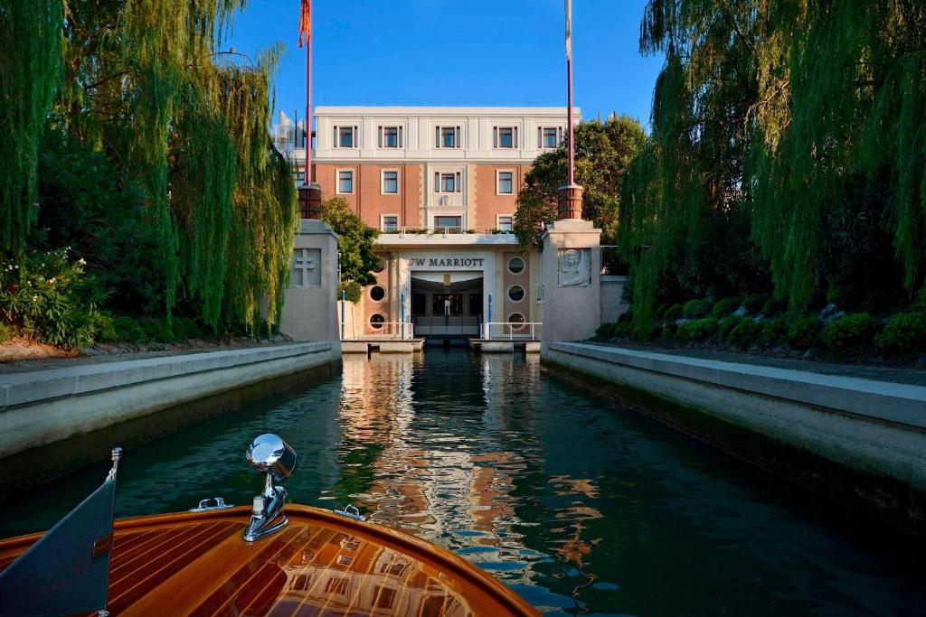 um barco num canal em frente a um edifício em JW Marriott Venice Resort & Spa em Veneza