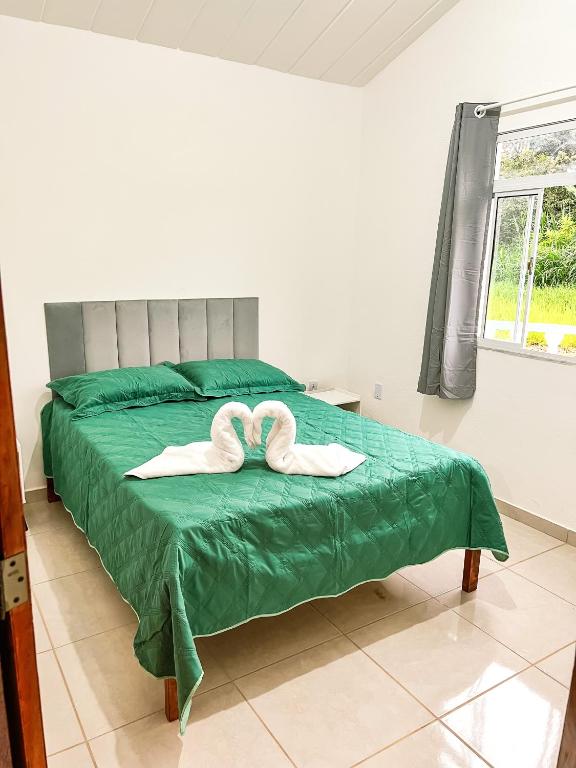 a bedroom with two towels on a bed at Temporada em Miguel Pereira in Miguel Pereira