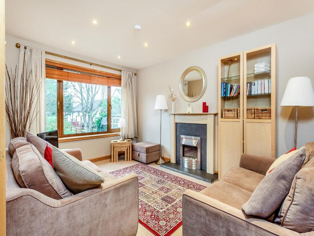 a living room with two couches and a fireplace at Dorrey View Cottage - Uk39010 in Halkirk