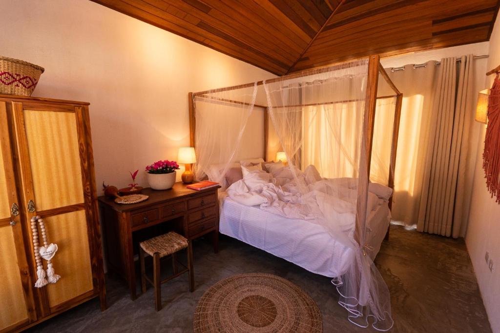 a bedroom with a canopy bed and a desk at Alma Iguassu in Foz do Iguaçu