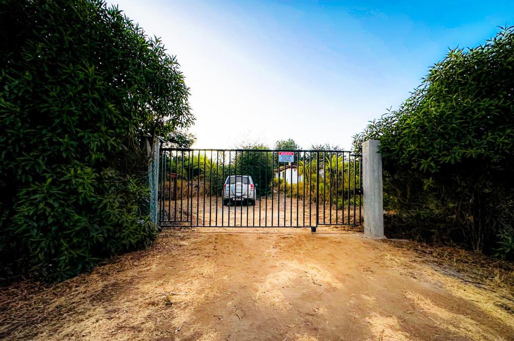 a gate with a car parked in a driveway at Cabañas Santa Rita in Cobquecura