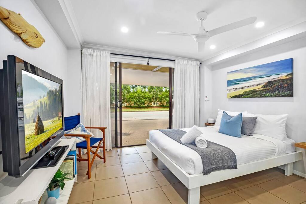 a bedroom with a bed and a tv in a room at Charming Coastal Studio 900m to the Beach in Kawana Waters