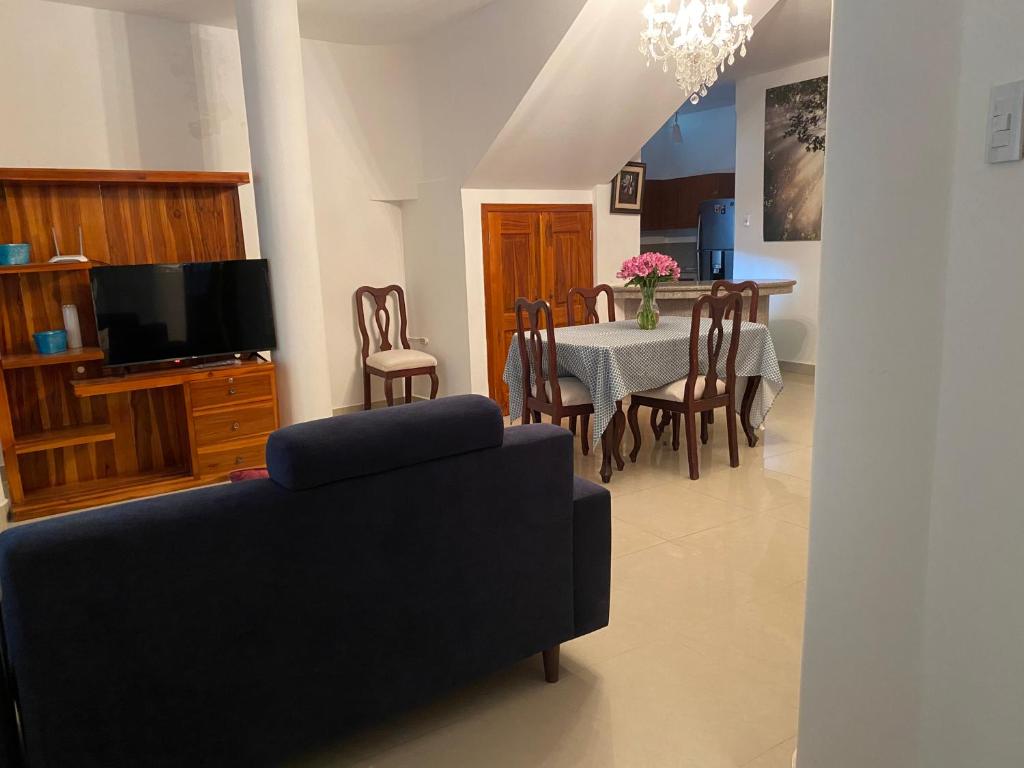 sala de estar con sofá y mesa con sillas en Casa Olguita en Manta