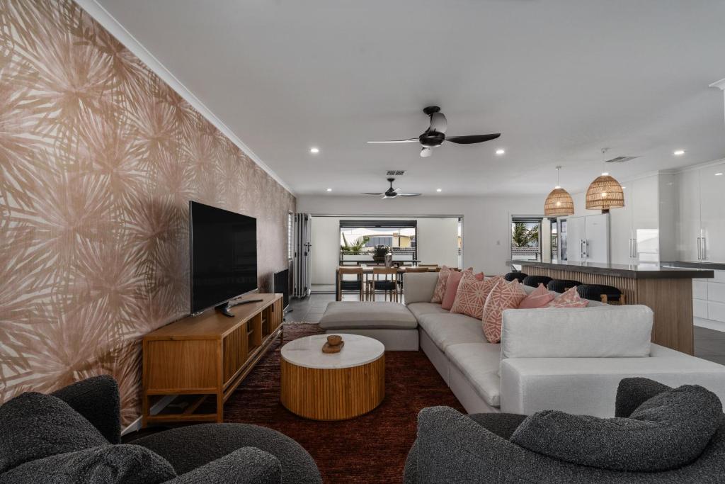 a living room with a couch and a tv at Nimolanca - 3 Bedroom Partial Ocean View in Caloundra