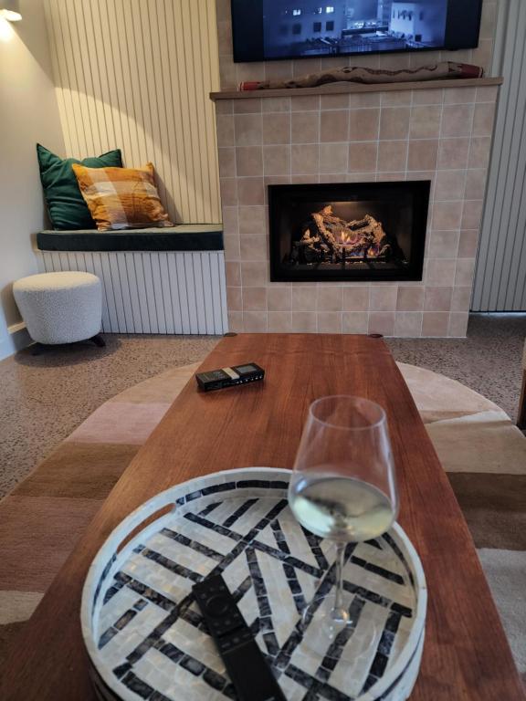 a glass of wine sitting on a table in front of a fireplace at 5 By the Church in Port Fairy