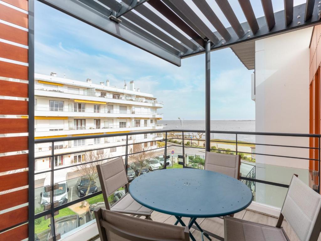 un balcon avec une table et des chaises et une vue sur l'océan dans l'établissement Appartement climatisé avec parking et balcon à Arcachon - FR-1-319-459, à Arcachon