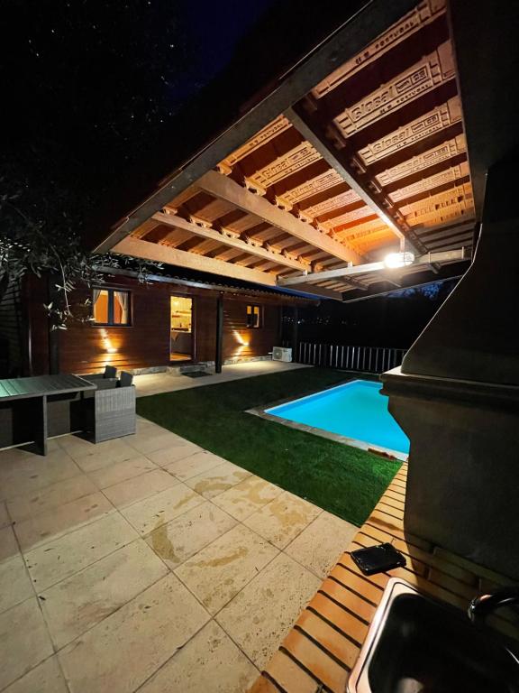 an outdoor patio with a swimming pool at night at Perfect Mountain Lodge with Pool in Fafião