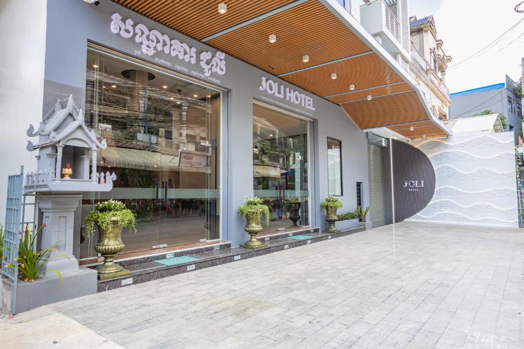 a store front with potted plants in front of it at Joli Hotel in Phnom Penh