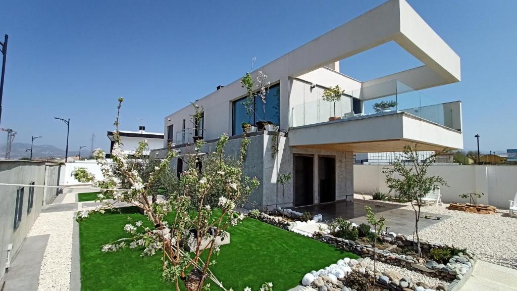 uma casa moderna com um quintal verde em Chalet con piscina y jardín, no fumadores ni fiestas em Cúllar-Vega