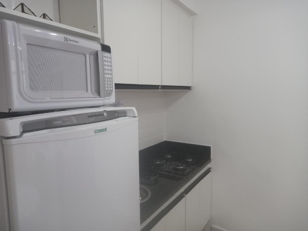 y cocina con microondas y nevera. en Suhcasa Bairro de Fátima 02, en Río de Janeiro