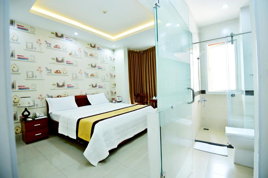een slaapkamer met een bed en een badkamer met een douche bij Hotel Thu Ha - Sân bay Tân Sơn Nhất in Ho Chi Minh-stad
