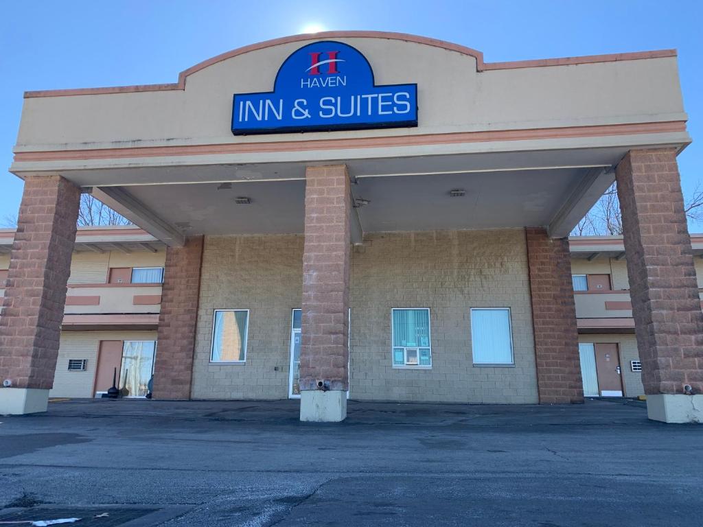 una posada y un edificio de suites con un cartel en Haven Inn & Suites St Louis Hazelwood - Airport North en Hazelwood