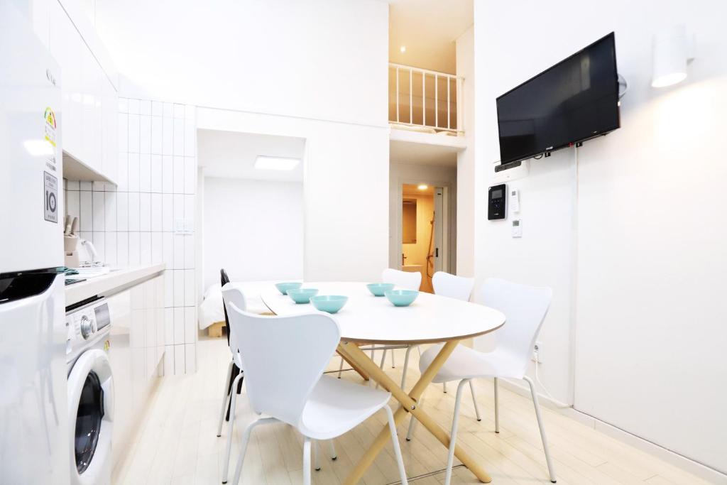 a kitchen and dining room with a white table and chairs at Apartment J garden Myeongdong Station in Seoul