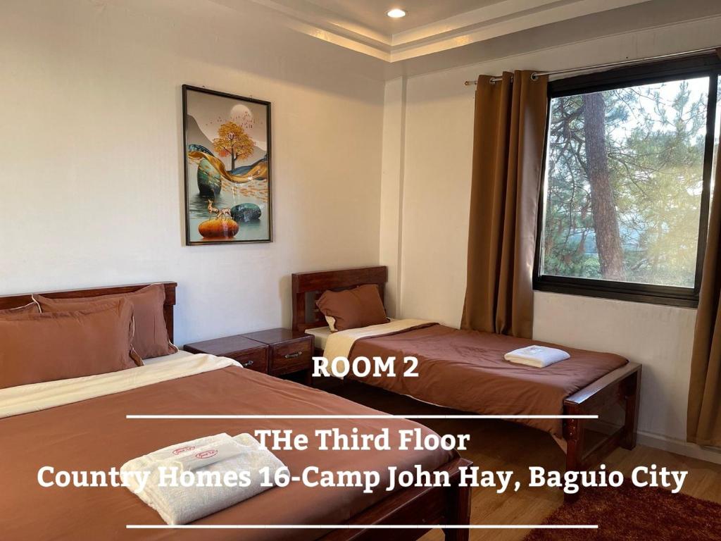 ein Hotelzimmer mit 2 Betten und einem Fenster in der Unterkunft The 3rd Floor Lot 16 Country Estates inside Camp John Hay- with view in Baguio City