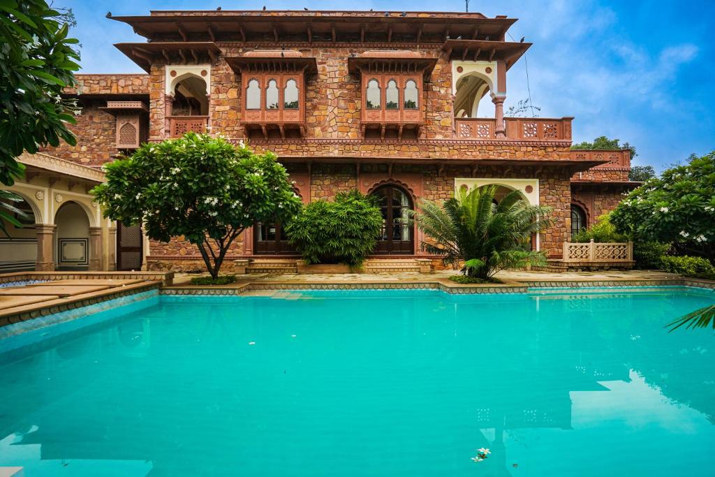 a house with a swimming pool in front of it at Khas Bagh in Jaipur