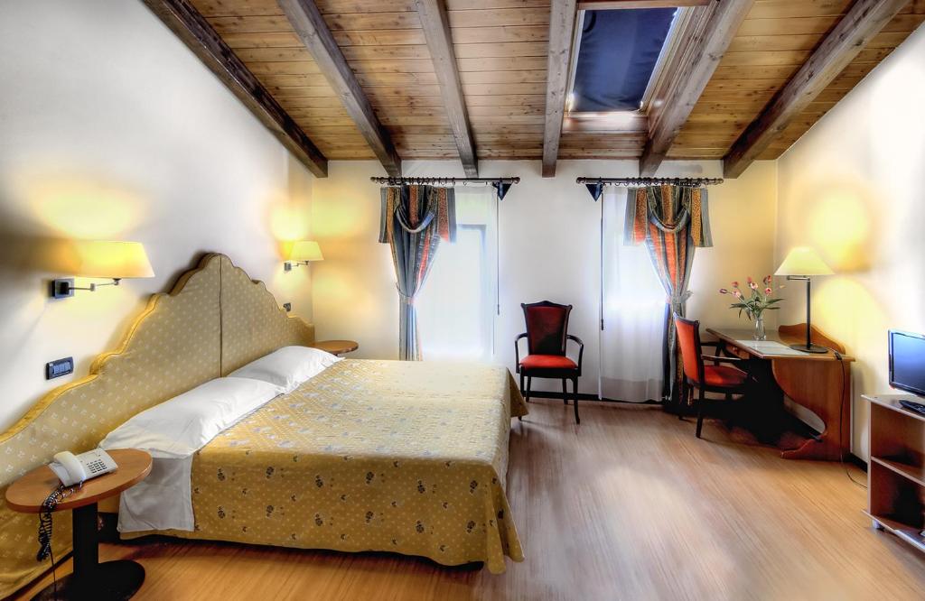 a bedroom with a bed and a desk and a television at Antica Locanda Il Sole in Castel Maggiore