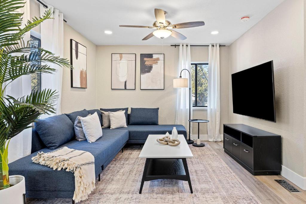 a living room with a blue couch and a tv at Elegant 4BD Reno Abode, close to Shops and Casinos in Reno