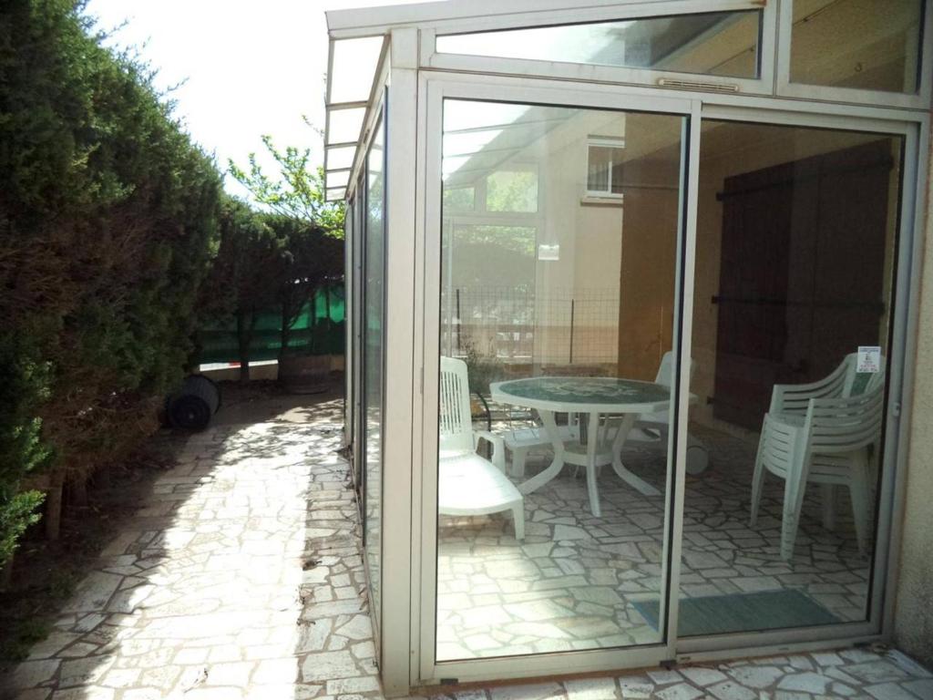 a glass door leading to a patio with a table and chairs at Appartement Narbonne, 4 pièces, 4 personnes - FR-1-229B-473 in Narbonne